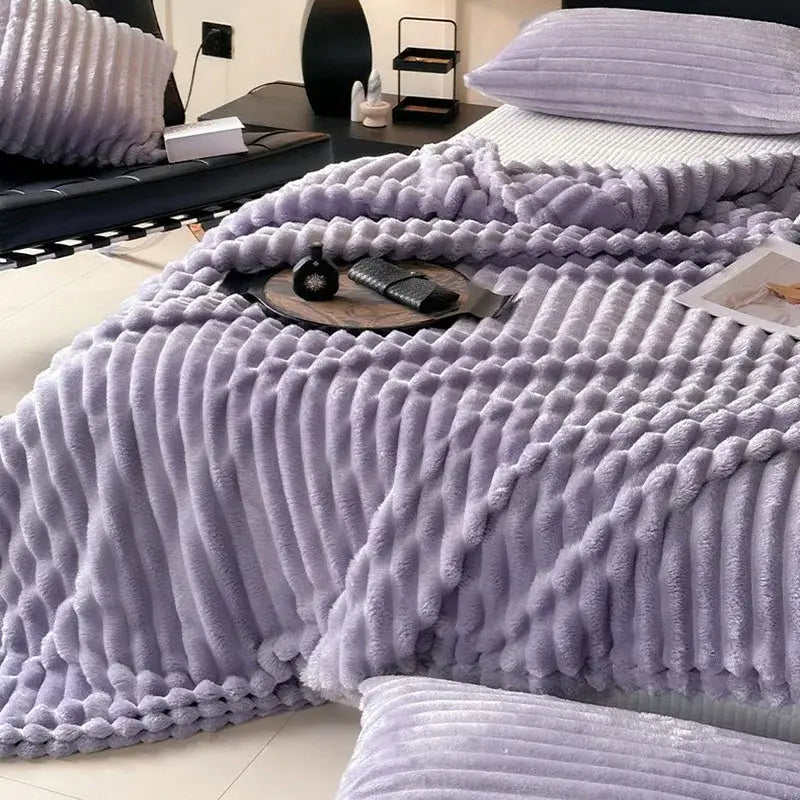 A cozy coral fleece throw blanket in lavender with a textured ribbed knit pattern perfect for living room decor