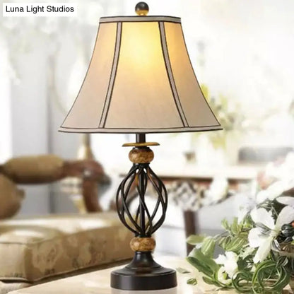 مصباح طاولة من القماش بتصميم ريفي دافئ مع قاعدة قفصية سوداء ملتوية - إضاءة ليلية مثالية لغرفة المعيشة