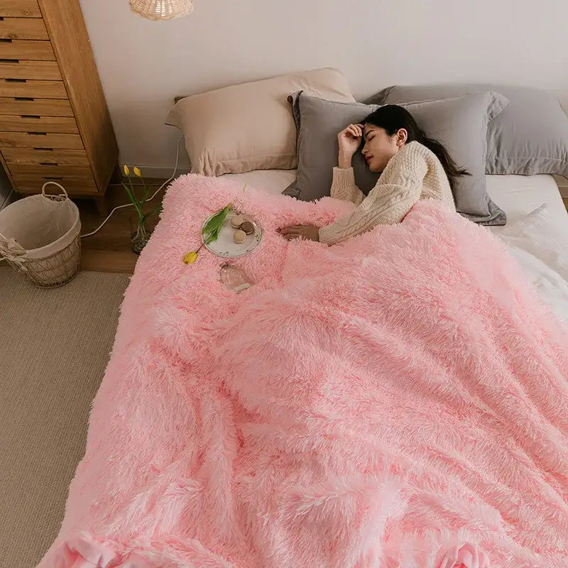 Soft pink cozy faux fur throw blanket with long plush fibers draped over a bed for warm decorbites cozy faux comfort