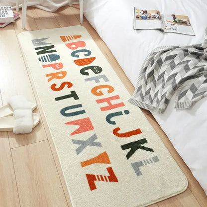 Cream-colored decorbites cozy faux lamb bedside rug with colorful alphabet letters in orange teal gray and black