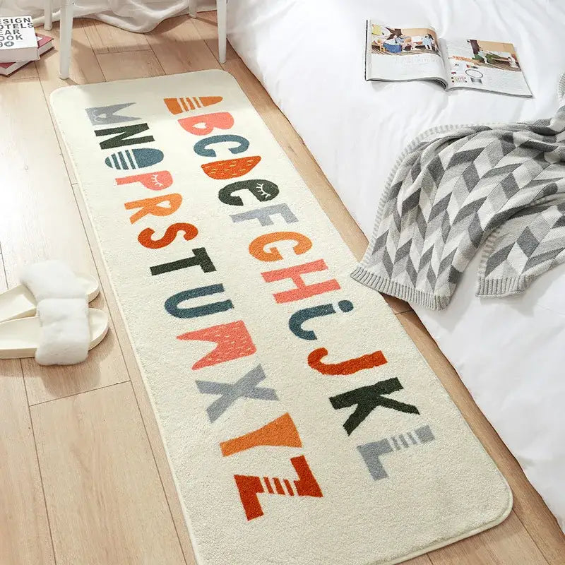 Cream-colored decorbites cozy faux lamb bedside rug with colorful alphabet letters in orange teal gray and black