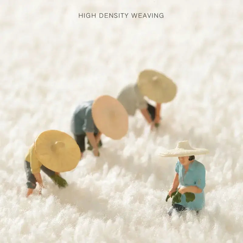 Miniature figurines of farmers with wide-brimmed hats near decorbites cozy faux lamb bedside rug for bedroom use