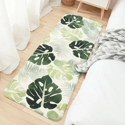A plush rectangular bedside rug with vibrant green tropical leaves on cream decorbites cozy faux lamb wool material