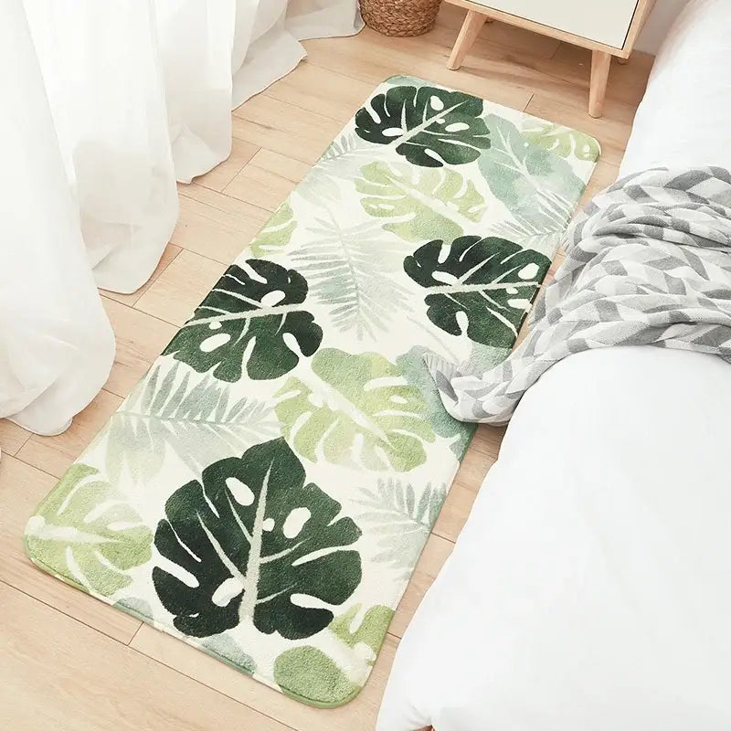A plush rectangular bedside rug with a vibrant tropical leaf pattern in green on cream decorbites cozy faux lamb wool