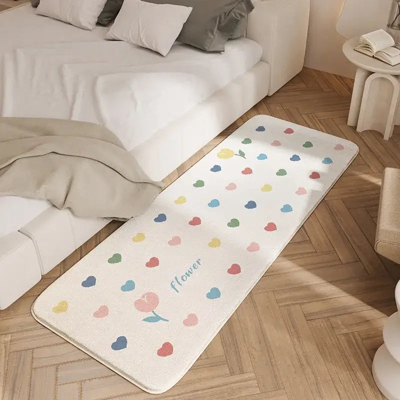 A soft off-white bedside rug with multicolored hearts and flower script made of decorbites cozy faux lamb wool