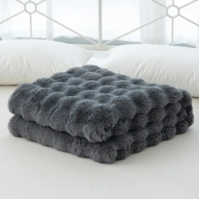 A plush dark gray faux rabbit velvet throw blanket with quilted tufted texture from decorbites cozy faux collection