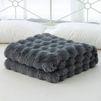 A plush dark gray faux rabbit velvet throw blanket with quilted tufted texture from decorbites cozy faux collection