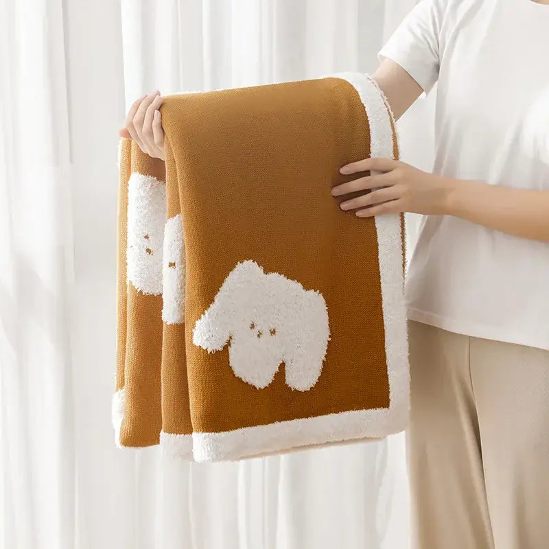 Warm brown decorbites cozy flannel blanket with fluffy white puppy appliqués and soft white contrasting border