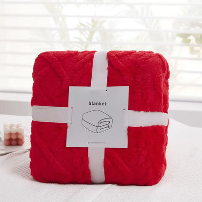 A plush blanket red decorbites cozy jacquard throw with textured knit pattern wrapped with white ribbons