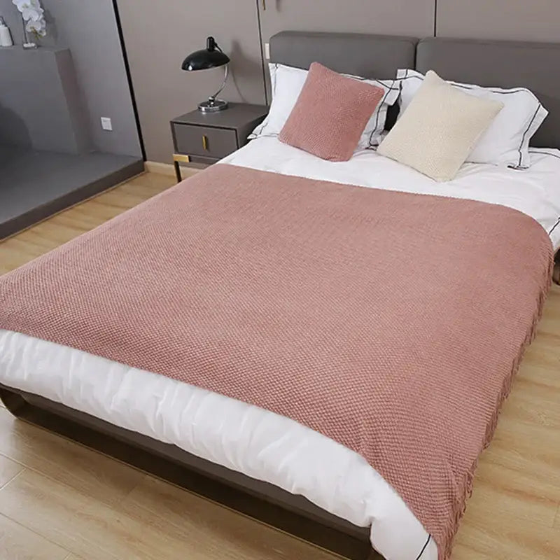 A soft dusty rose decorbites cozy knitted sofa blanket with textured weave and fringed edges for living room decor