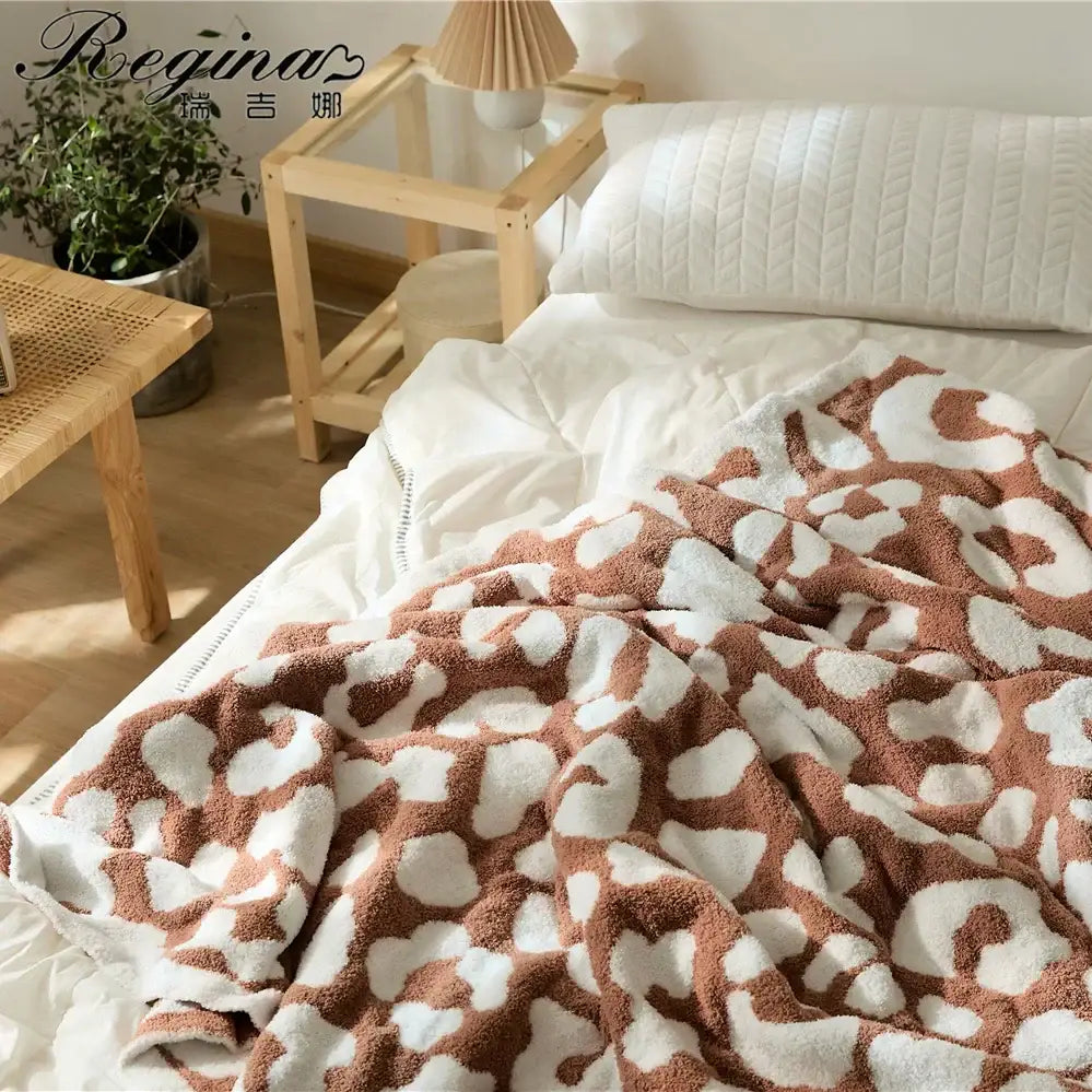 Cozy leopard print knitted cream and gray bedroom throw blanket with brown and white patterned fleece plush texture