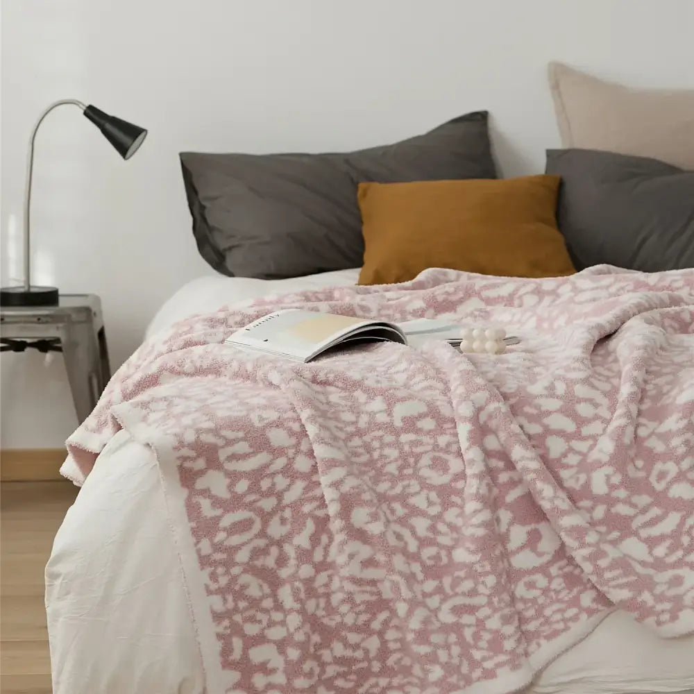 Pink leopard-print fleece throw blanket showcasing decorbites cozy leopard print knitted design for bedroom decor