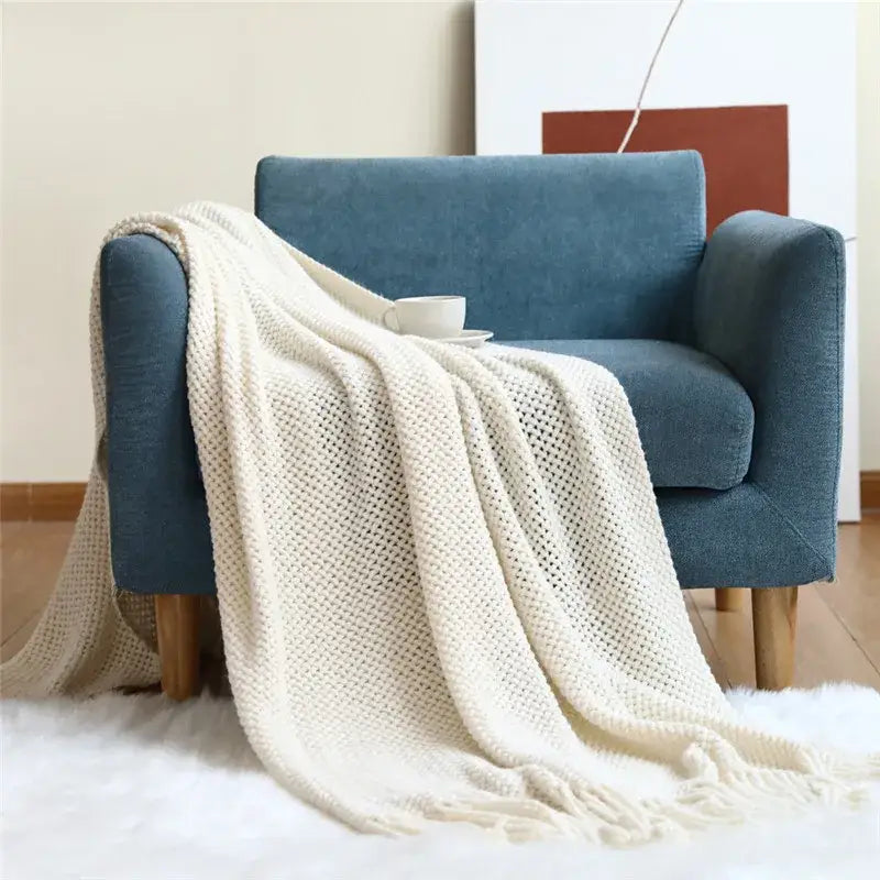 Cream-colored chunky-knit cozy nordic knit throw blanket with textured mesh pattern and tassels for living room decorbites cozy nordic