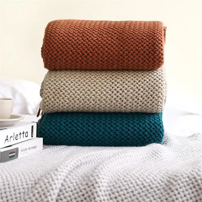 Stack of three cozy nordic knit sweaters in terracotta beige and teal with textured weave for nordic knit sofa decorbites