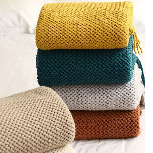 Stack of five cozy nordic knit textured tassel throw blankets in mustard yellow teal gray terracotta and beige for sofa decorbites cozy nordic