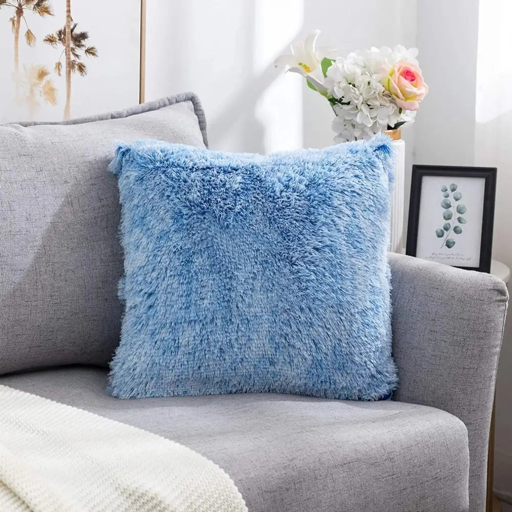 A cozy plush fur light blue cushion cover with soft shaggy texture on a gray sofa for decorbites cozy plush decor