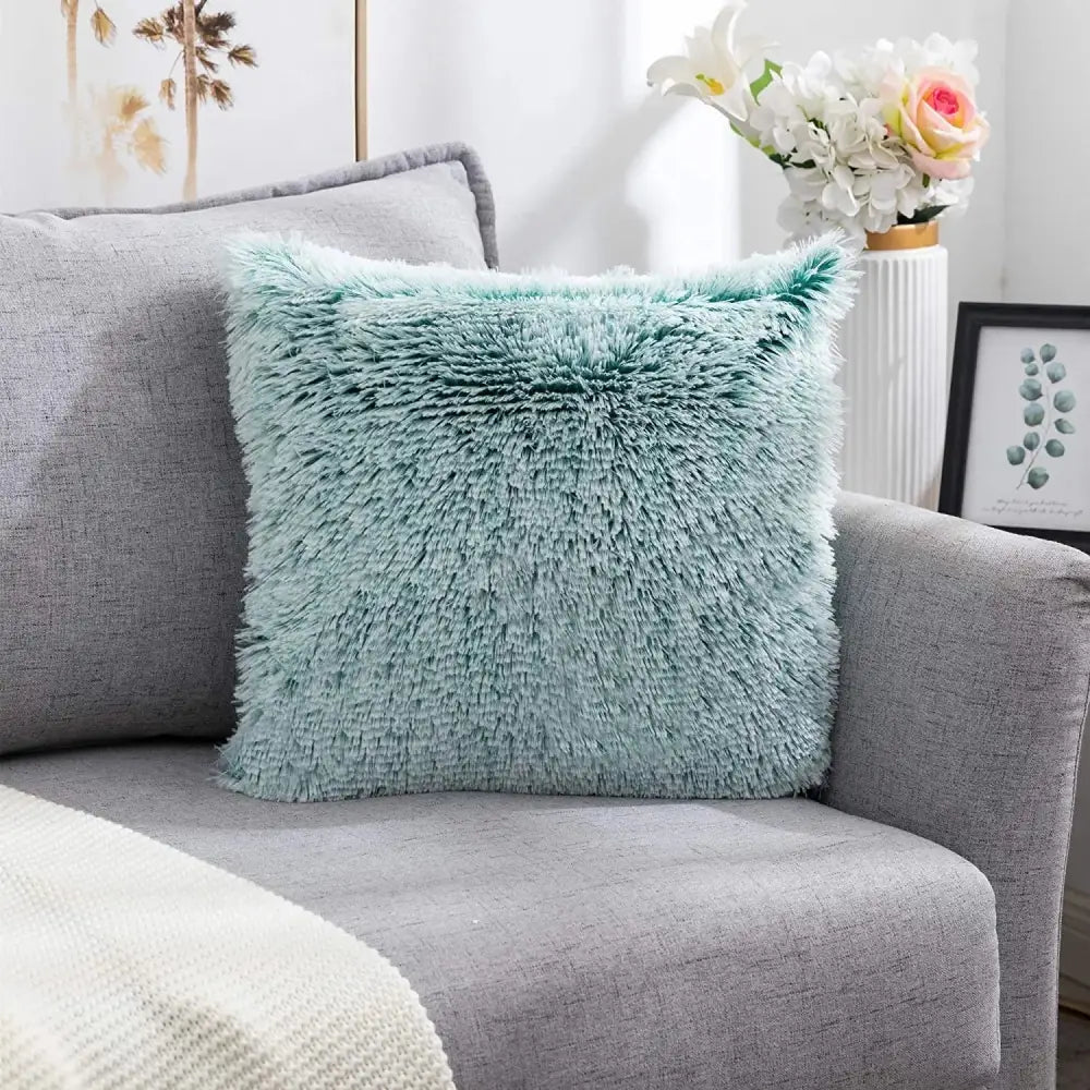 A soft mint green cozy plush fur cushion cover with shaggy texture on a gray sofa by decorbites cozy plush