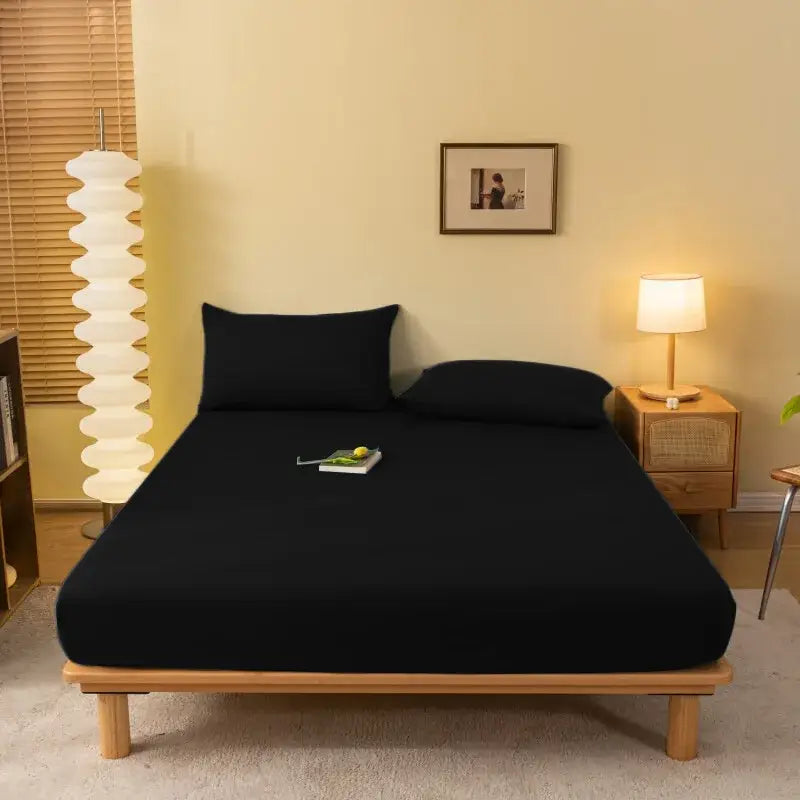 Black fitted sheet with smooth stretchy fabric snugly covering mattress and pillows decorbites cozy solid color