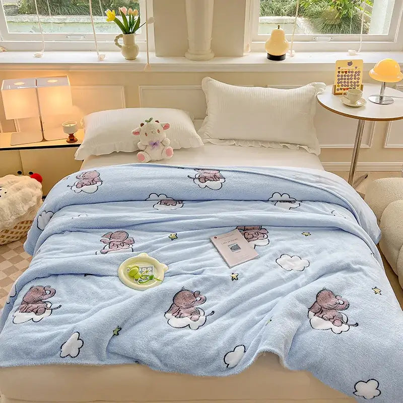 Light blue plush blanket with cartoon elephants on clouds paired with cozy white fleece blanket with colorful flower patterns for bedroom decor