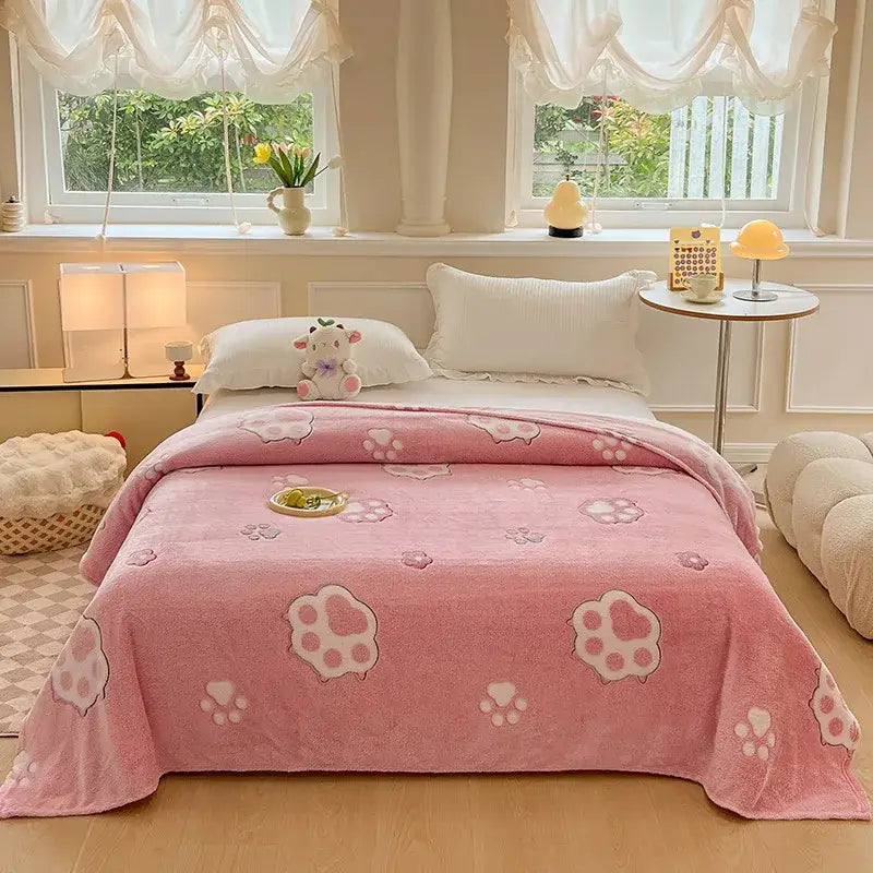 Pink plush blanket with soft fuzzy texture and lighter pink paw prints complements colorful flower patterns decor