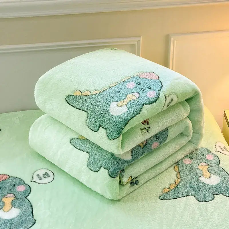 A soft mint green plush blanket with embroidered cartoon dinosaurs and colorful flower patterns for bedroom decor