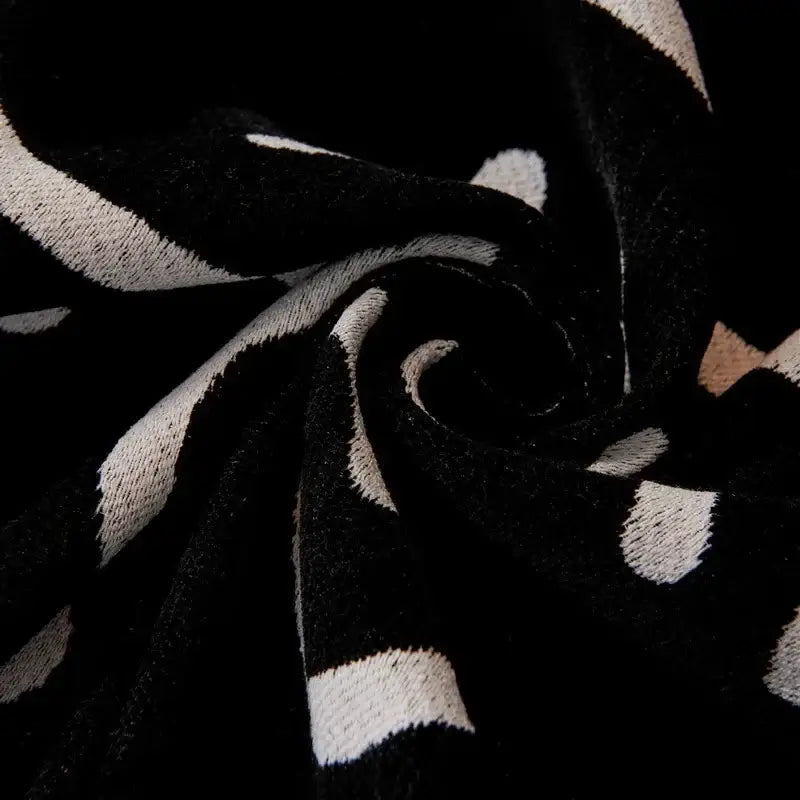 Cream and black cat print chenille sofa cover with black and white striped knit fabric and soft textured weave