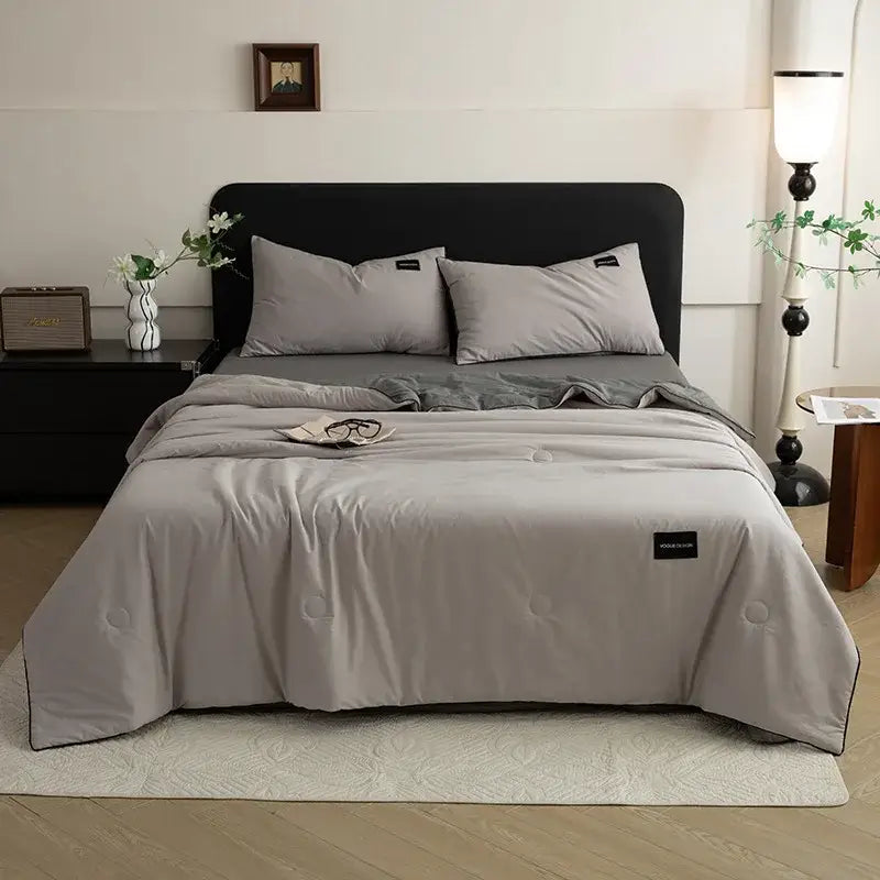 Gray quilted comforter with subtle circular stitching and black brand tag in cream and black ice cream cool feel summer quilt set decorbites ice cream