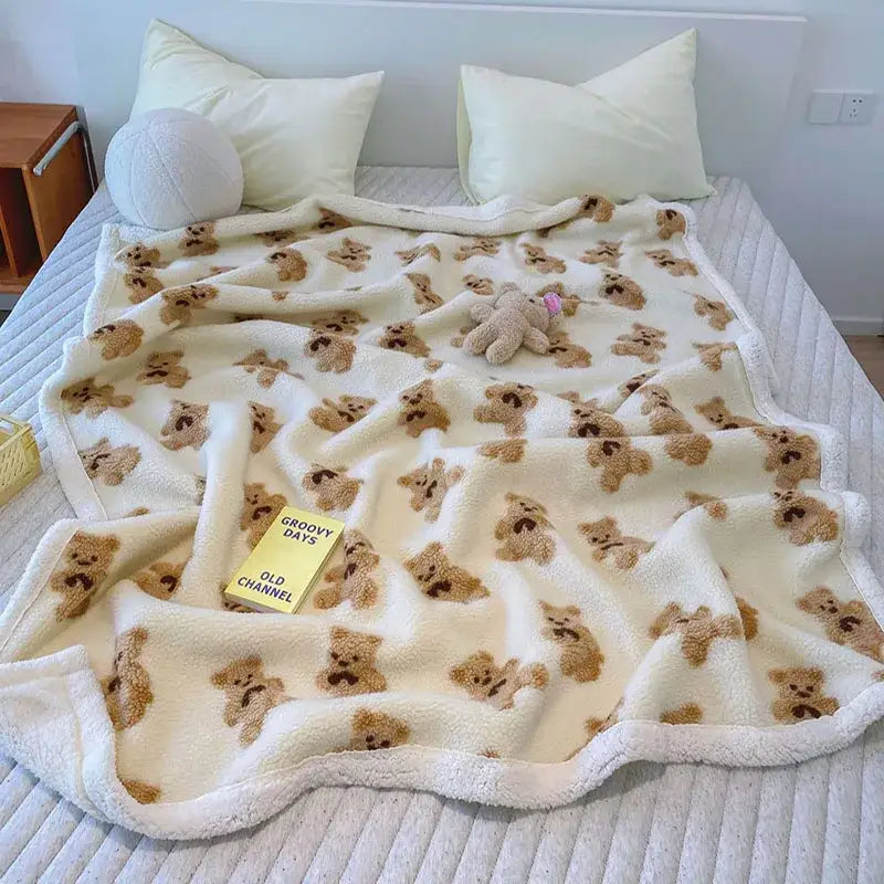 Cream and brown bear lamb plush cream-colored plush blanket with repeating teddy bear pattern edged in white fleece