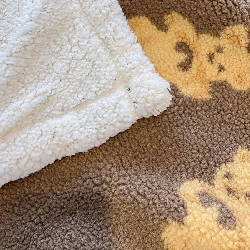 Cream and brown bear lamb plush blanket with soft embroidered bear faces in yellow made of fleece for bedroom use
