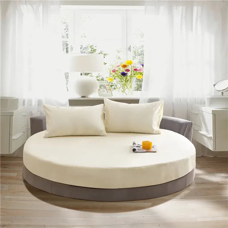 Cream and gray round fitted bed sheet set on a cream circular bed with gray base and matching pillows for bedroom decor
