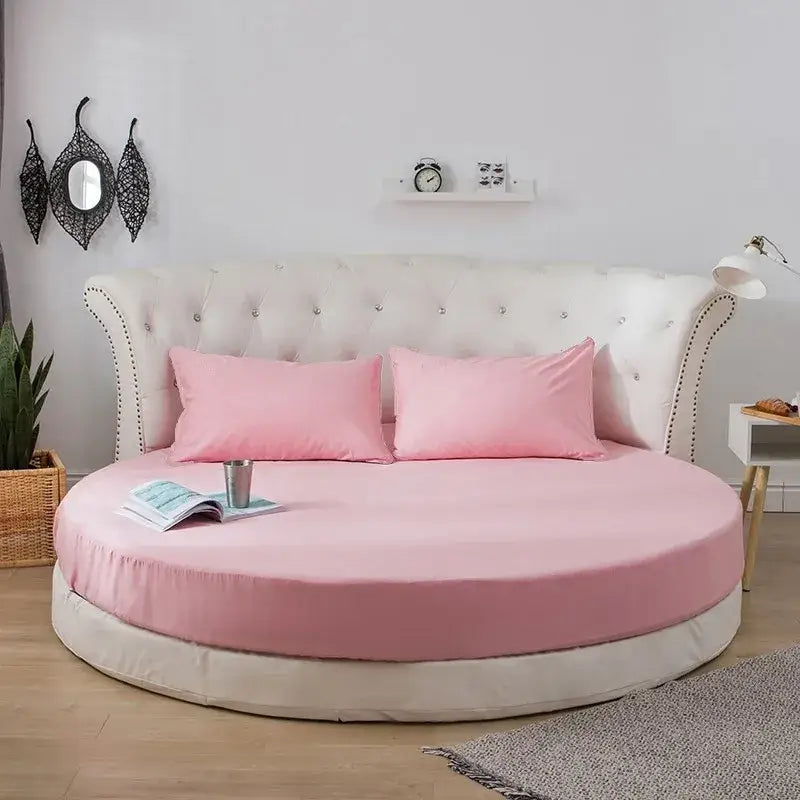 Pink round fitted bed with tufted white headboard and matching pillowcases in cream and gray bed sheet set