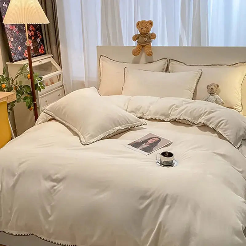 Cream-colored satin bedding set with delicate black trim and cozy shell edges for decorbites cozy shell bedroom decor