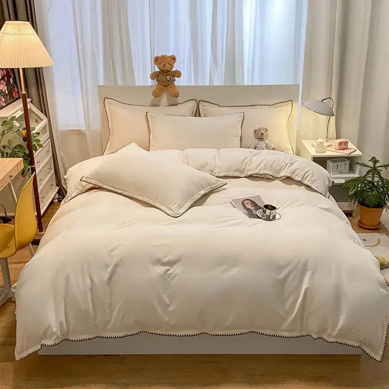 Cream-colored satin duvet bedding set with delicate scalloped cozy shell edges and subtle piping trim for decorbites cozy shell