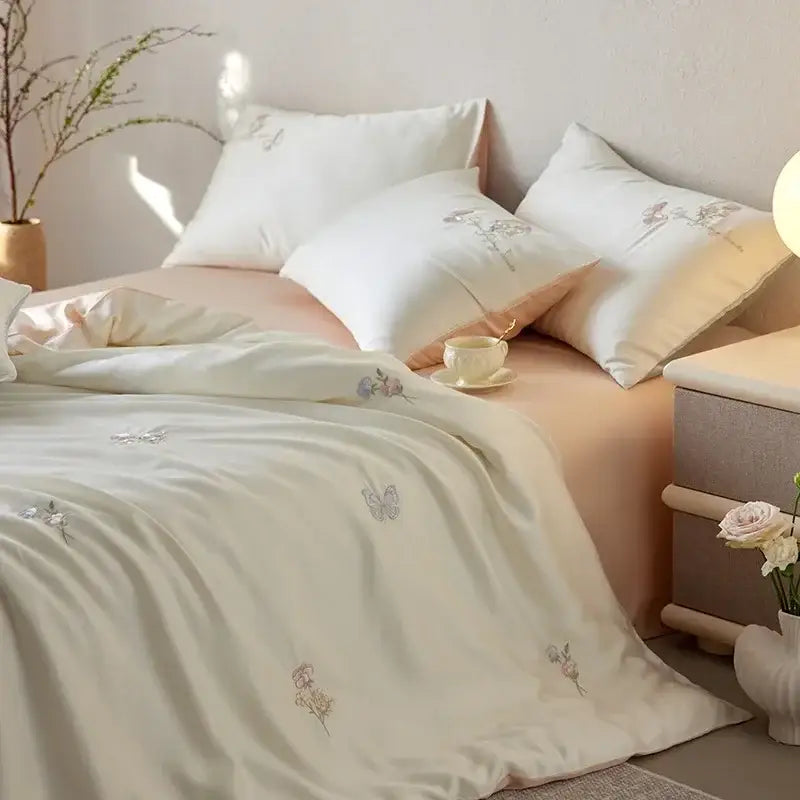 Cream-colored satin comforter set with delicate cartoon embroidery floral and butterfly motifs by decorbites