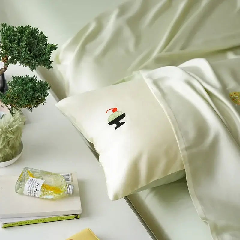 Cream-colored satin pillowcase with delicate cartoon embroidery of an ice cream sundae in decorbites comforter set