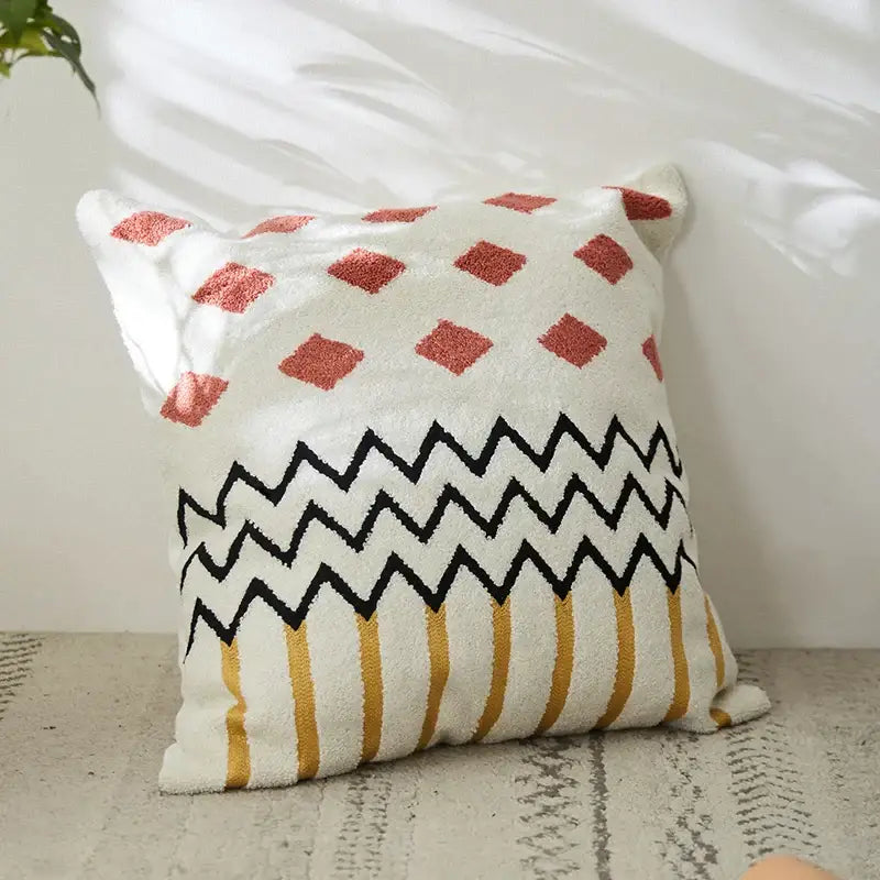 Cozy white embroidered cushion cover with rust diamonds, black zigzags, and mustard stripes for living room decor