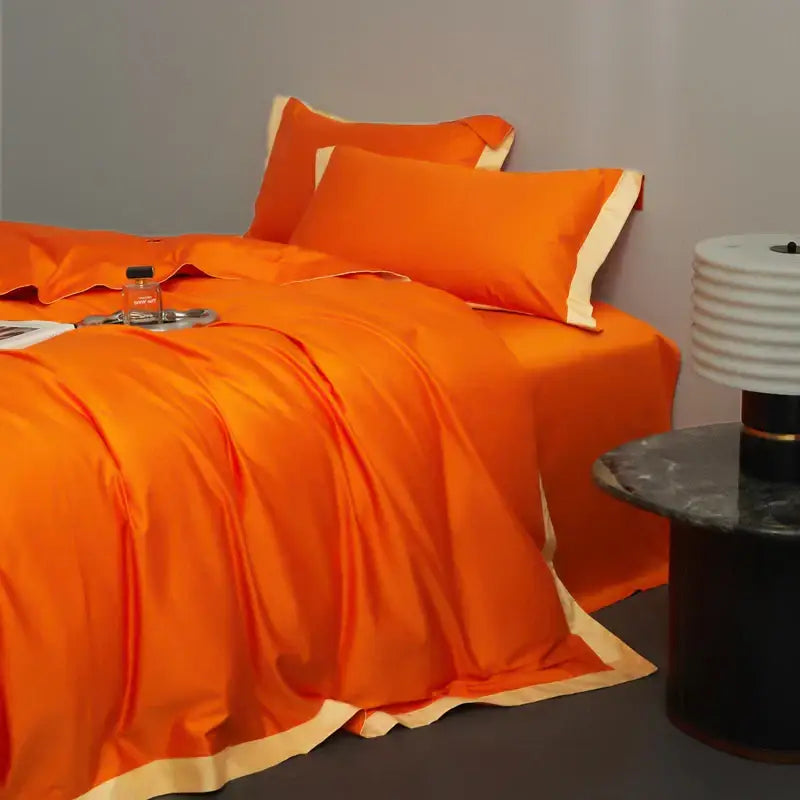 Vibrant orange satin bedding set with cream piping accents paired with cream and lavender egyptian cotton hotel style sheets