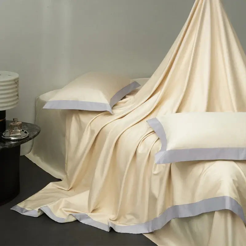 Cream-colored satin bedding set with subtle gray piping made from egyptian cotton hotel style fabric for bedroom use