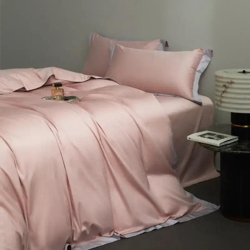 A soft pink satin duvet cover bedding set with white trim in egyptian cotton hotel style for bedroom use