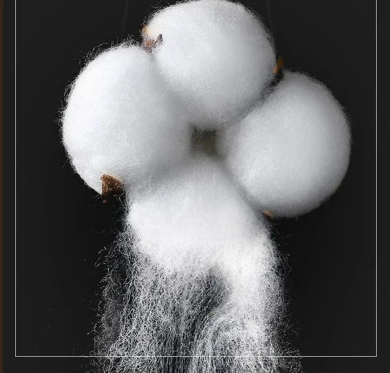 Plush white cotton boll with fluffy fibers and brown stem representing cream and lavender egyptian cotton hotel bedding set