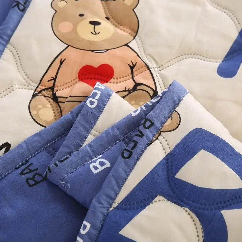 Cream bear quilt and pillowcase set featuring a soft cream bear quilt with a stitched teddy bear and blue binding bedding set