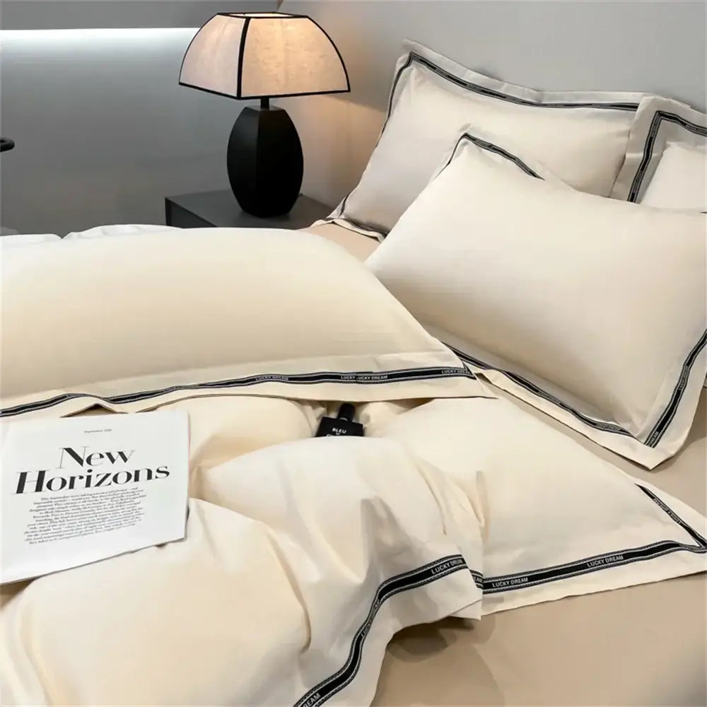 Cream and black egyptian cotton bedding set with satin texture and lucky dream text along striped trim edges
