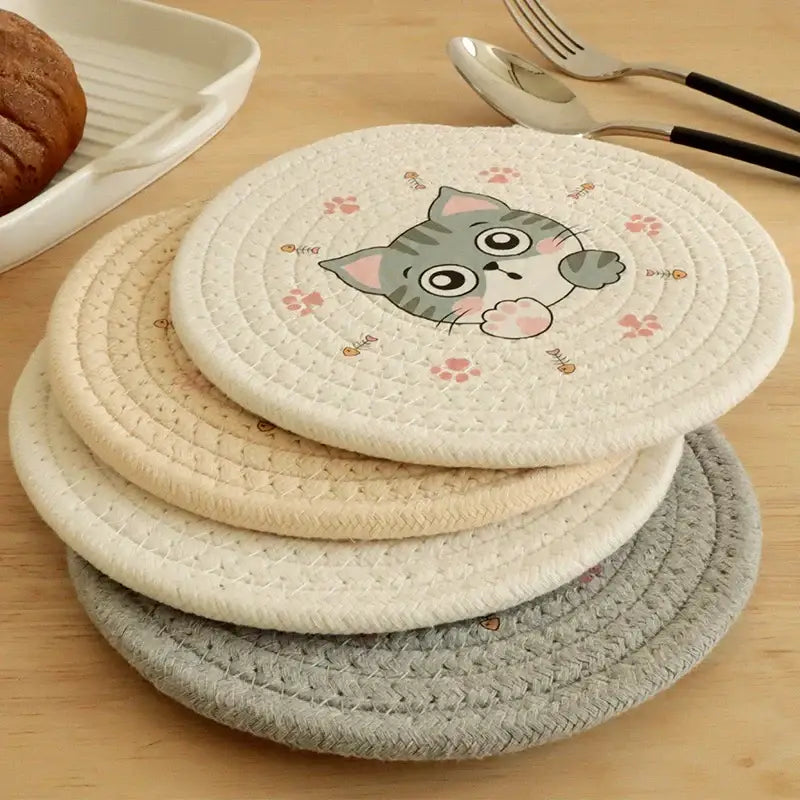 Cream braided rope cat print round coaster featuring a gray tabby cat design with pink paw prints and fish motifs