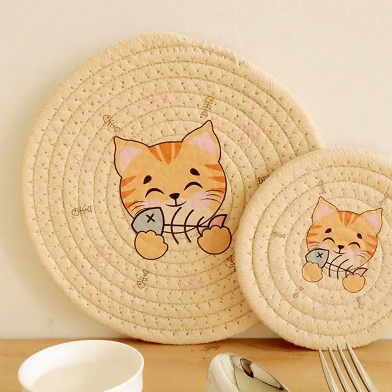 Cream braided rope round coaster in cream with cat print featuring an orange tabby holding fish bones decorbites cat print