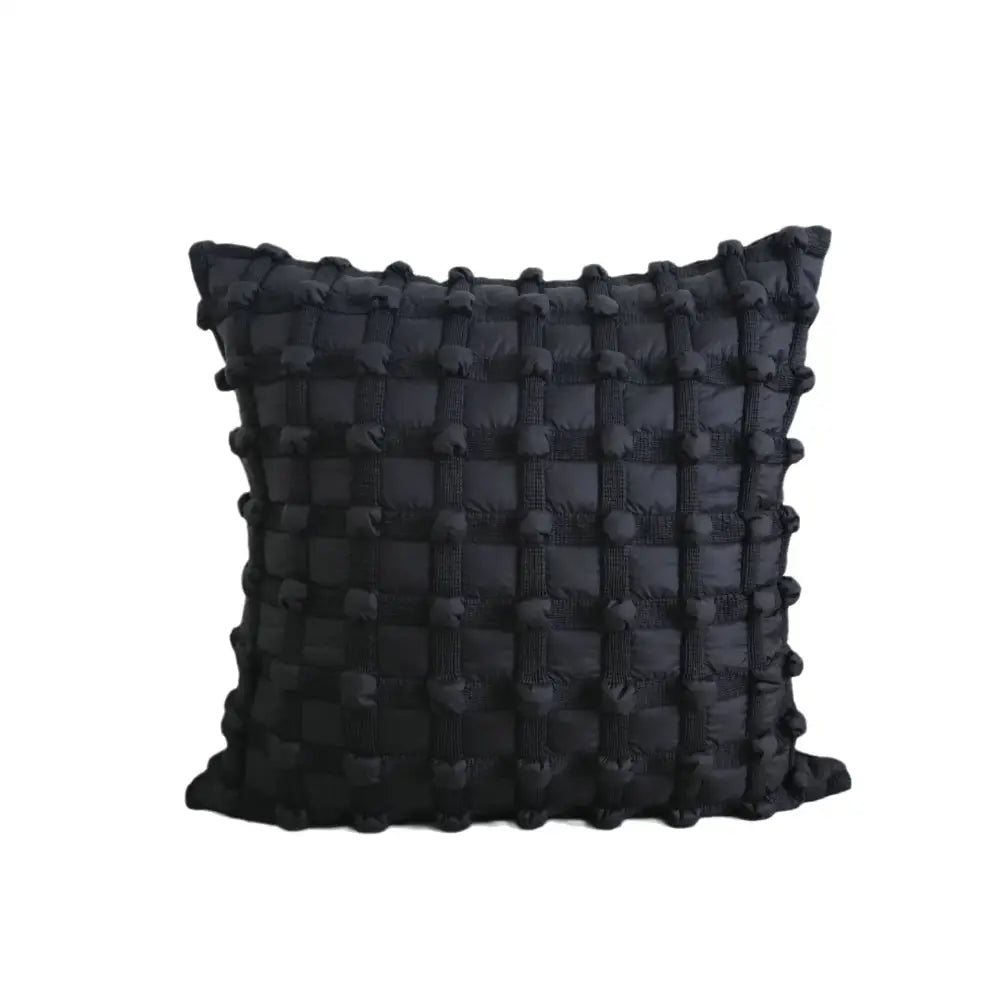 Black cushion cover with textured woven bubble plaid pattern and raised pom-poms for decorbites bubble plaid decor