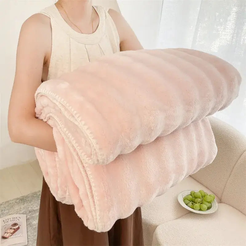 A plush soft pink fleece bubble velvet woolen sofa blanket with ribbed texture and cream stitched edges for decorbites decor