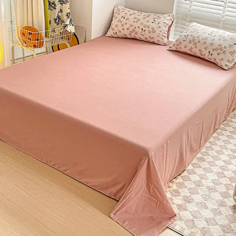 Soft pink cartoon pattern cotton bedding set with subtle textured weave neatly draped over mattress decorbites