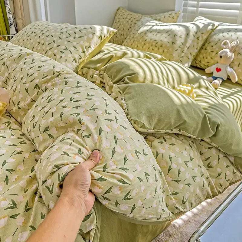 A soft pale green duvet cover with delicate white blossoms and dark leaves in a decorbites cartoon pattern cotton bedding set