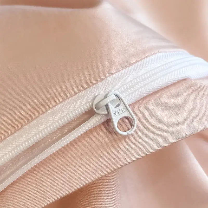 A sleek silver YKK zipper on soft peach satin fabric in a cream butterfly embroidery 800tc Egyptian cotton bedding set