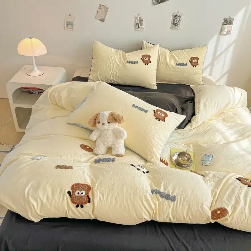 Cream cartoon embroidery jacquard comforter set in cream with embroidered brown toast characters and blueberry accents